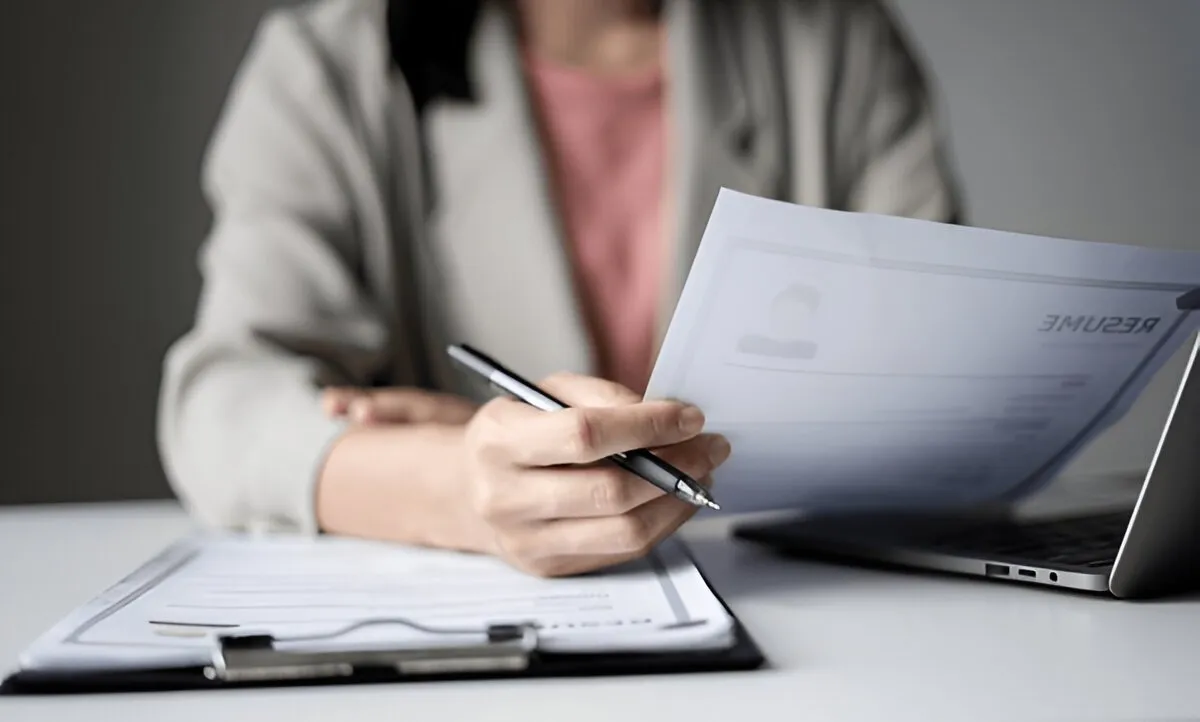 How Much Do Recruiters Make Per Hire? Recruiter reviewing resumes and calculating commission per hire