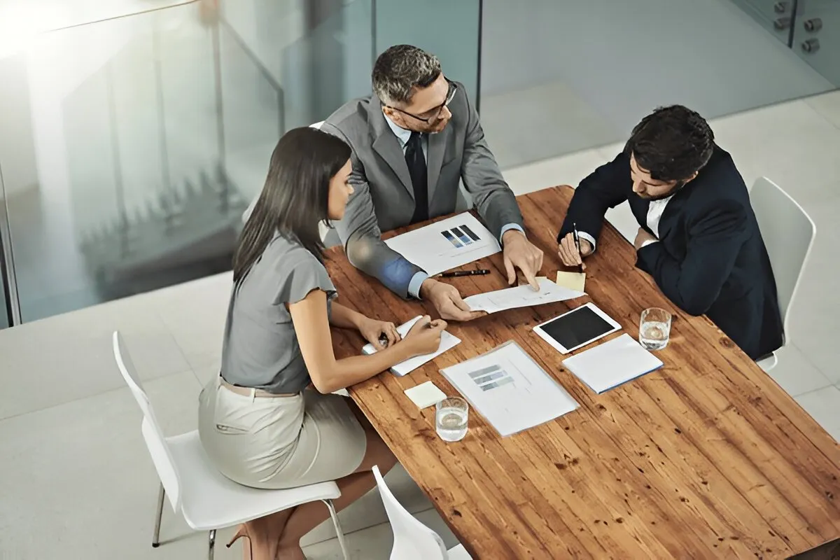 How to Become a Business Consultant Without a Degree Business consultant discussing strategy with a client at a desk