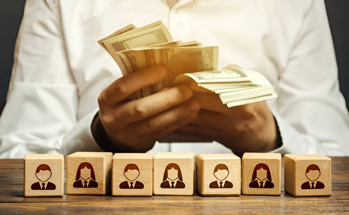How Much Do Recruiters Make Per Hire? Recruiter reviewing resumes and calculating commission per hire