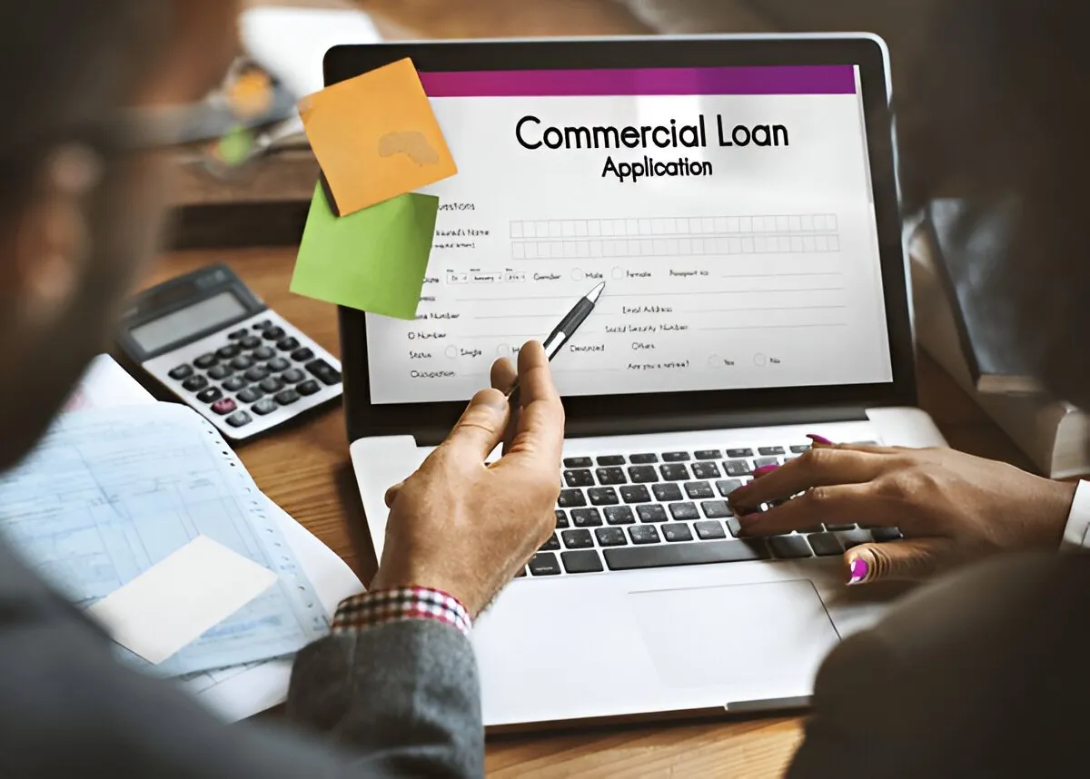 How to Get a Commercial Loan With No Money Down Business owner reviewing commercial loan documents with a banker